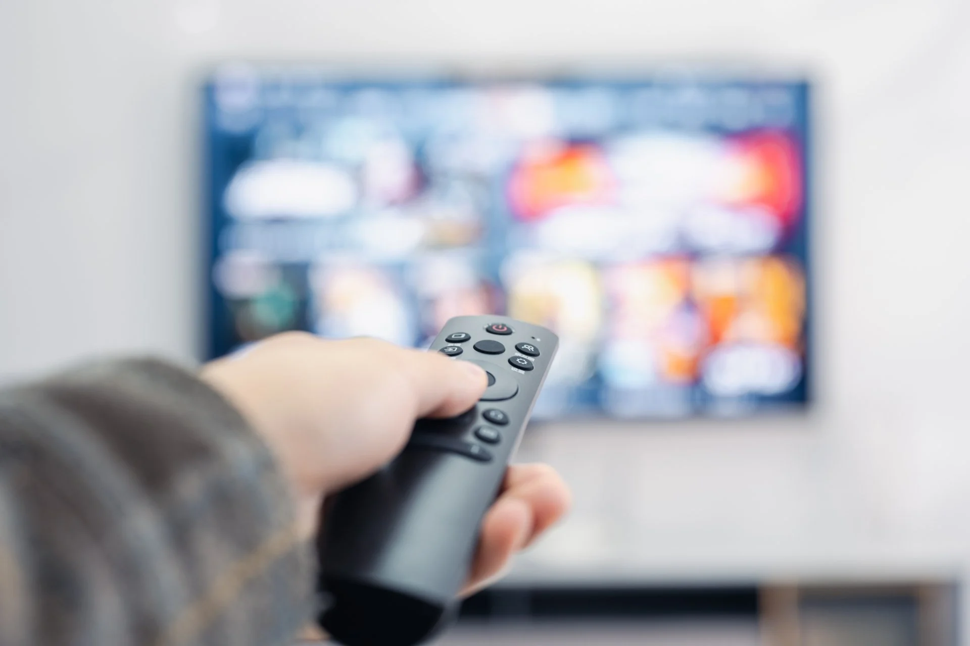 Person framför en tv med en fjärrkontroll