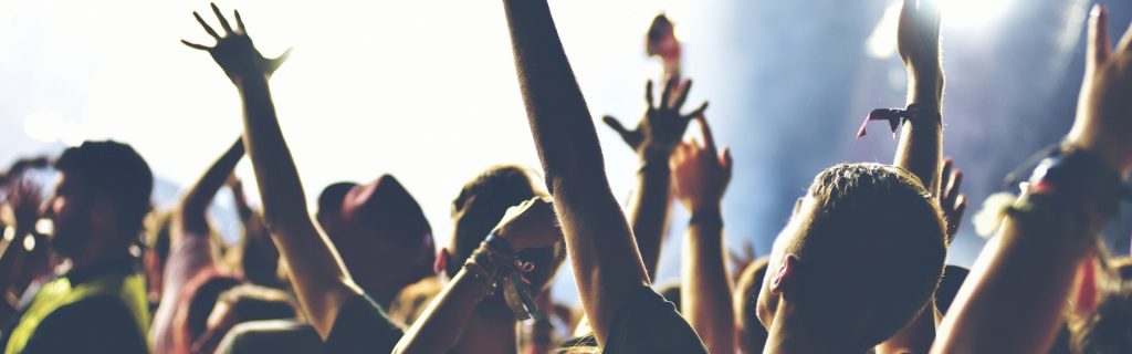 Publik med uppsträckta armar på en konsert